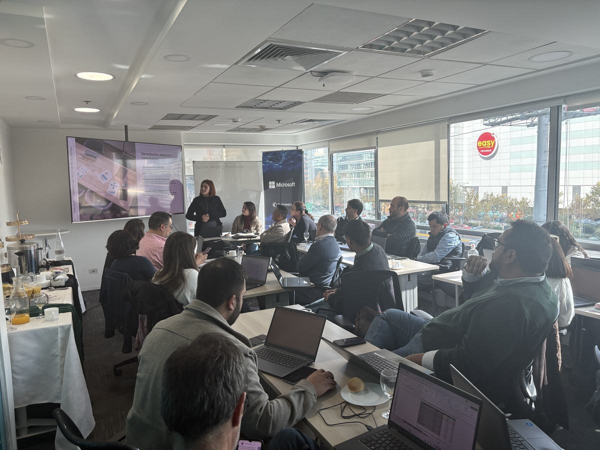 Sesión presencial del programa: un relator frente a una pantalla con la presentación IA Generativa y M365 Copilot, y participantes con sus notebooks.